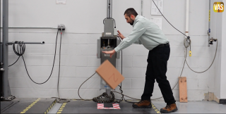 an employee at the Value-Added Services lab performs a drop test on a corrugated box